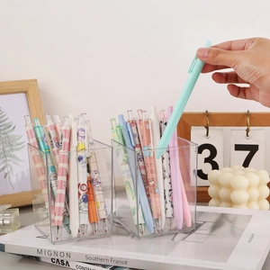 Porte-stylo minimaliste en acrylique avec stylos colorés sur un bureau chaleureux