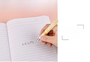 Close-up of yellow rollerball pen with a 0.38mm tip writing on a lined notebook