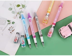 Close-up of creative syringe-shaped rollerball pens in multiple colors with vaccine-themed prints