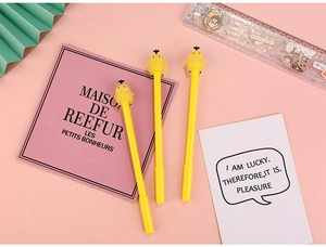 Détail de trois stylos créatifs en forme de poussin jaune sur fond de bureau rose