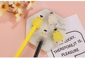 Détail des capuchons de stylos en silicone poussin sur une surface en marbre chic