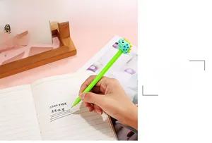 Detail of 0.5mm tip dinosaur gel pen writing smoothly on paper with a cute green topper