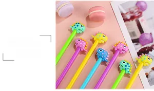 Detailed view of colorful cartoon dinosaur pens with 3D silicone caps on a pink background