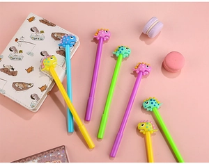 Flat lay of colorful dinosaur gel pens with cute 3D toppers on a pink workspace