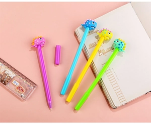 Set of four colorful cartoon dinosaur gel pens in purple blue yellow and green on a desk