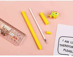 Macro view of disassembled yellow dinosaur gel pen with glitter ruler on pink background