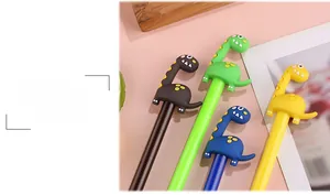 Dettaglio di penne gel a forma di dinosauro cartoon in nero, verde, blu e giallo vivace