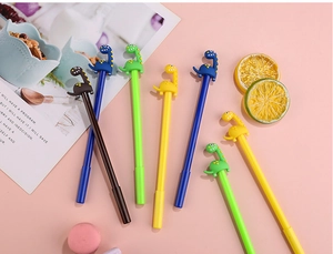 Simpatiche penne gel a forma di dinosauro in quattro colori su una scrivania rosa
