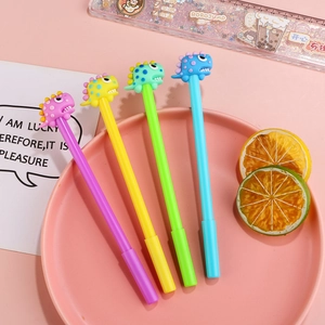 Set of four colorful cartoon dinosaur gel pens in a pink decorative tray