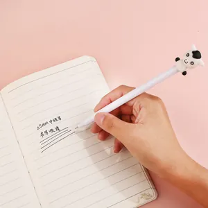 Close-up of a 0.5mm cartoon pen writing smoothly on a notebook with cow mascot