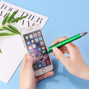 Close-up of green 3-in-1 stylus ballpoint pen with integrated phone stand on desk