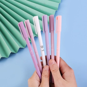 Close-up of Morandi colored gel pens with matte finish held against a blue background