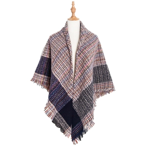 Detailed view of checkered knit texture and fringe edge on a thick winter shawl