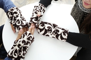 Detalle macro de guantes de franela de invierno gruesos con patrón paisley blanco y negro