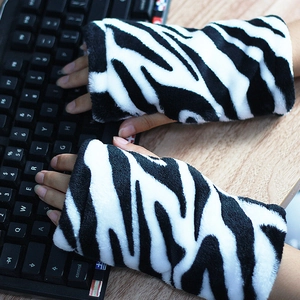Guantes sin dedos de piel sintética de cebra usados mientras se escribe en un teclado