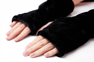 Vista detallada de guantes sin dedos de felpa negra gruesa con textura de piel sintética