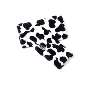 Detalle de guantes sin dedos de felpa con estampado de vaca y agujero para pulgar