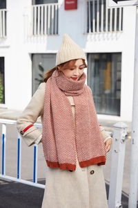 Detail of red and white herringbone knit scarf and beige ribbed beanie winter set