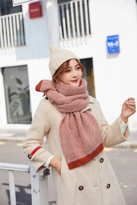 Detail showing the orange and beige herringbone knit pattern of the winter scarf