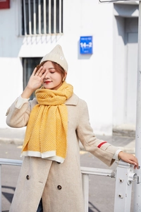 Close-up of ginger herringbone knit scarf and off-white ribbed beanie for winter fashion
