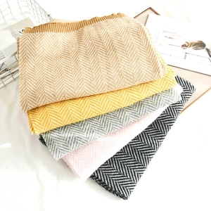 Detail showing various colors of herringbone knit scarves and ribbed edge texture