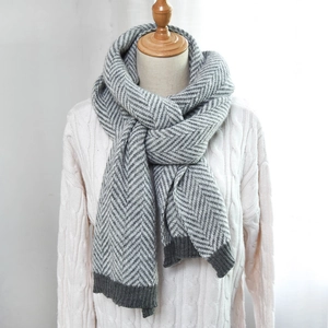 Classic gray herringbone knit scarf for men and women with ribbed edges on a mannequin