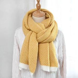 Detail of yellow herringbone knit scarf with ribbed edge and thick warm texture