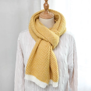 Detailed herringbone knit pattern on a yellow and white scarf with ribbed edge trim