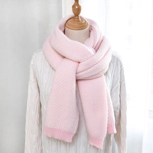 Detailed view of pink herringbone knit scarf texture with ribbed edges on a mannequin