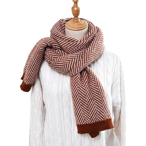 Detail of brown and white herringbone knit pattern on thick winter scarf with ribbed cuff