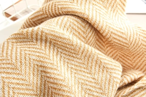 Macro shot of yellow and beige herringbone knit scarf with soft premium texture