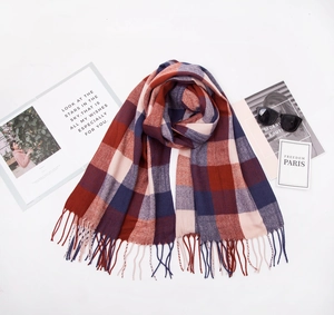 Detailed flat lay of red plaid cashmere-like scarf with fringe and stylish accessories