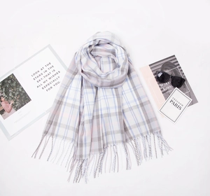 Close-up of pastel plaid scarf with soft fringe edges and a cozy cashmere-like texture