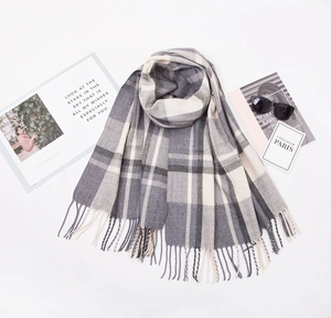 Detail of grey and beige plaid cashmere-feel scarf with fringe and stylish accessories