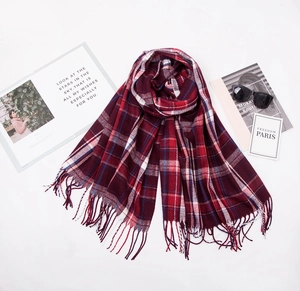 Detail shot of red plaid cashmere-like scarf with fringe edges and classic patterns