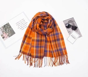 Detailed view of orange and blue plaid cashmere scarf texture with fringe tassels