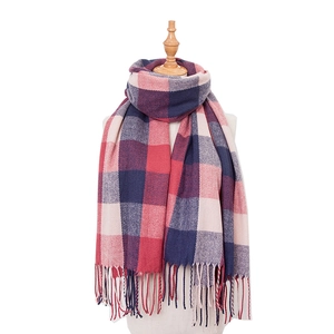 Close-up of red and navy plaid cashmere-like scarf with fringe detail on wooden mannequin