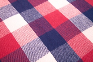 Macro shot showing the thick texture of red and navy blue plaid cashmere-like fabric