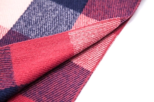 Macro view of thick red and navy plaid scarf with soft twill weave texture