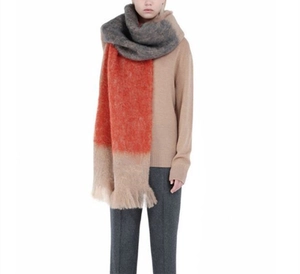 Close-up of thick mohair scarf with grey orange cream stripes and long fluffy tassels