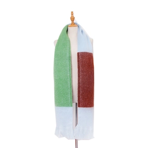 Close-up of soft knit tri-color striped scarf with green, blue, and brown fringe detail