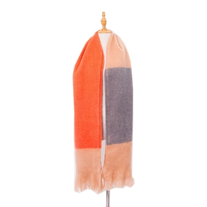 Detail of soft thick color-block scarf with vibrant orange and blue stripes and tassels