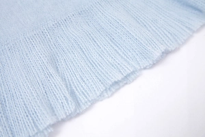 Detail of soft light blue knit mohair scarf showing ribbed texture and dense weave