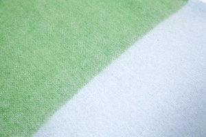 Close-up detail of soft fuzzy green and blue mohair striped scarf texture and colors