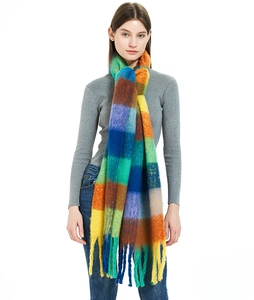 Detail of colorful plaid mohair scarf featuring long fringe and soft thick knit texture