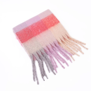 Detail of soft mohair texture and twisted tassels on a colorful plaid scarf