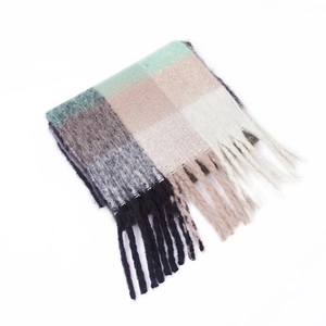 Detail shot of rainbow plaid mohair scarf with soft green tones and long fringed tassels