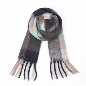 Detailed close-up of thick winter scarf showing textured plaid knit and chunky tassels