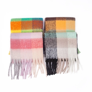 Close-up of four thick mohair-style scarves featuring colorful plaid patterns and long tassels