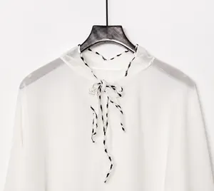 Detail of off-white chiffon sun protection shawl with a leopard print self-tie neckline